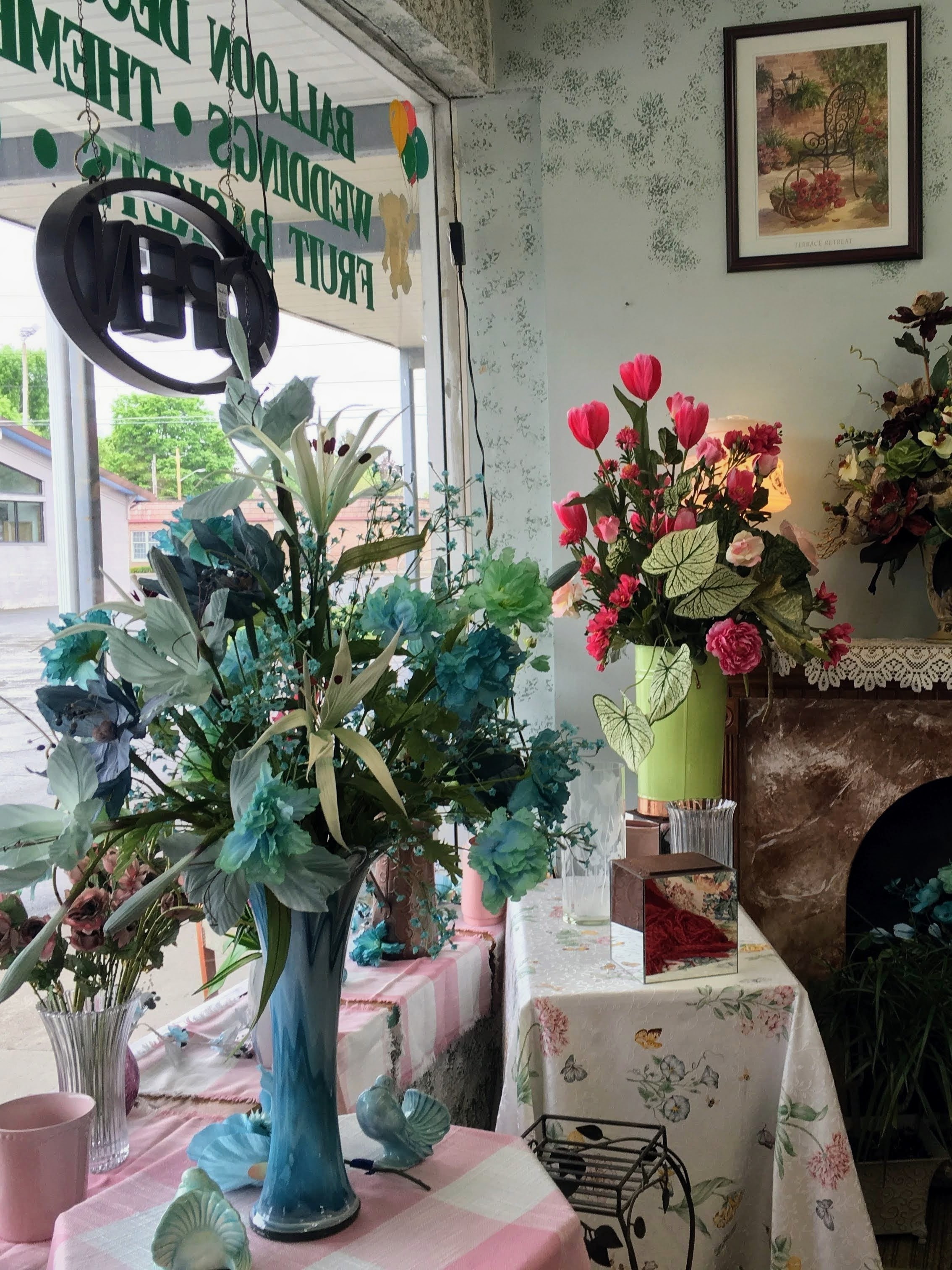 Vases with silk flowers displayed in window